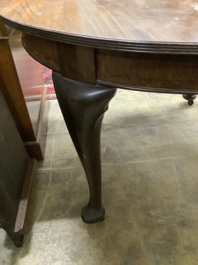 A 1920's circular mahogany extending dining table with three leaves and handle, length approx. 230cm